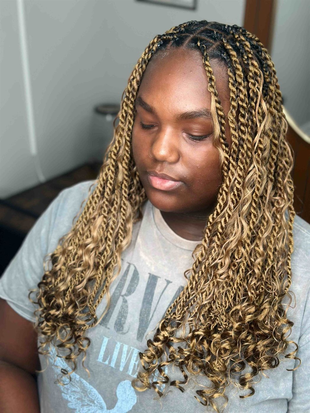 Honey blonde island boho twists with loose curly ends, seen from the front