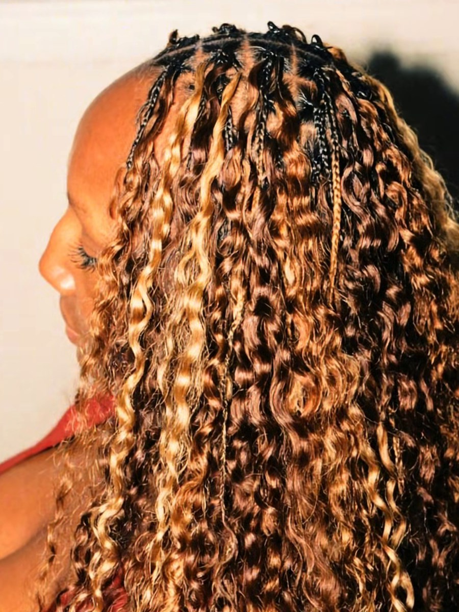 A client in profile wearing long honey-highlighted boho braids with loose curls, styled at Miracle Braid Lounge
