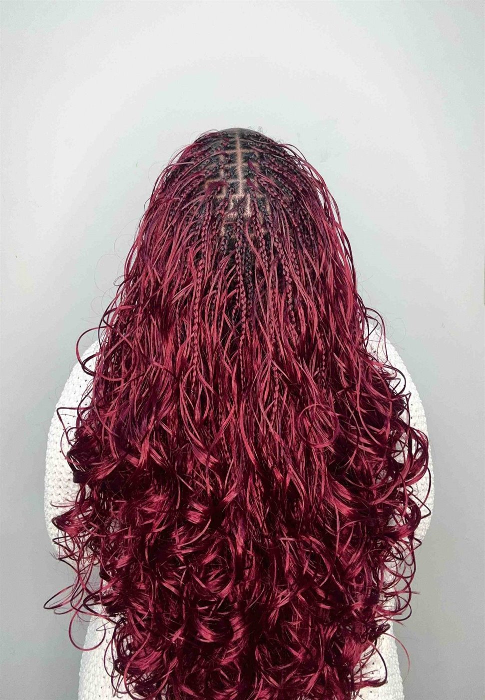 Long burgundy Bora French curl braids with loose curls through the length, seen from behind