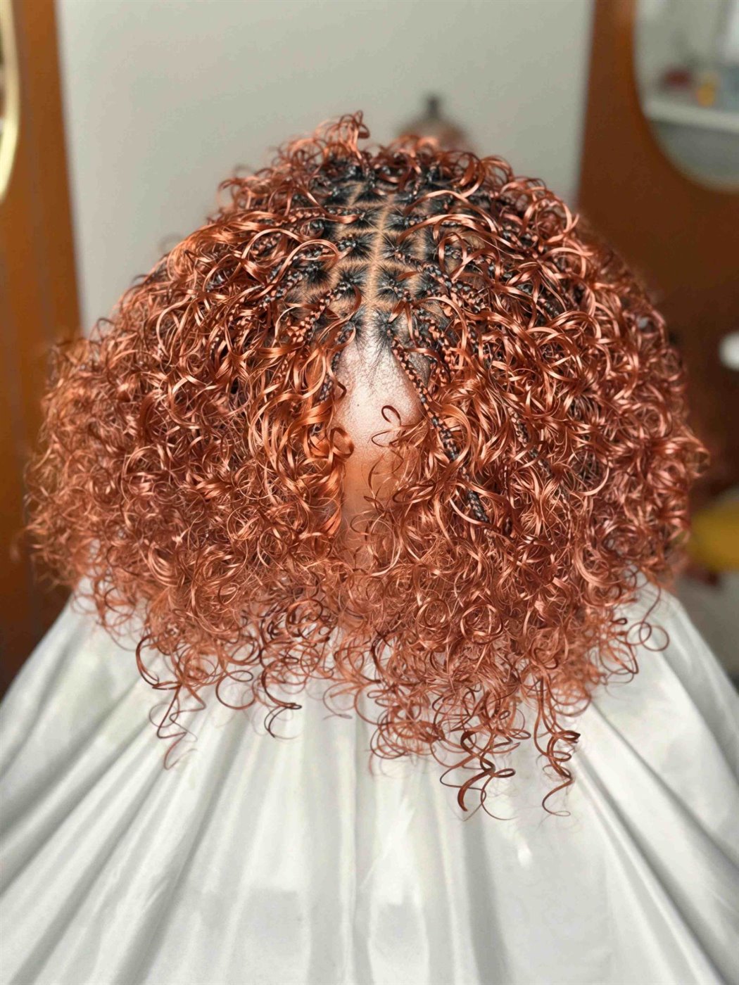 Copper Italian braids seen from above, full curls around a neat grid of parts